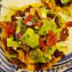 Tostadas with Spicy Chicken, Black Beans, Goat Cheese, and Avocado Enhanced Pico de Gallo